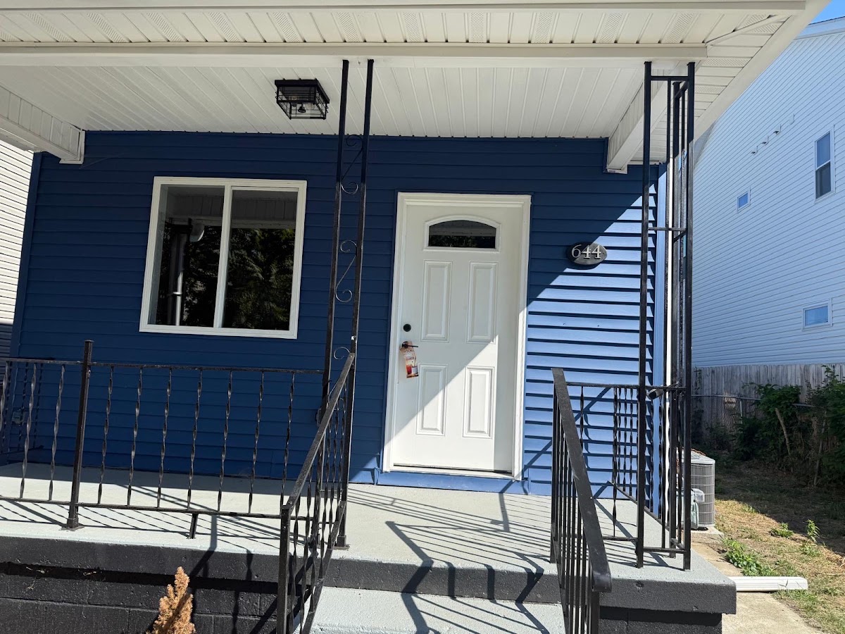 Finished exterior painting job, blue siding and new front door